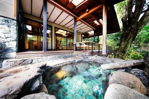 a hot tub in the backyard of a house at Yumeguri no Yado Yoshiharu in Izunokuni