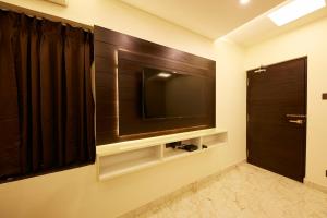a room with a television and a mirror at Al Noor Palace Business Class Hotel in Chennai