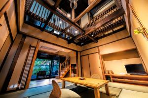 a living room with a wooden table and chairs at Yumeguri no Yado Yoshiharu in Izunokuni