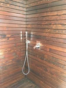a bathroom with a wooden wall with a hose attached at CASA DO MAR in Jardim do Mar