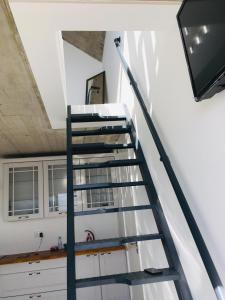 a ladder leading up to a room with a tv at CASA DO MAR in Jardim do Mar