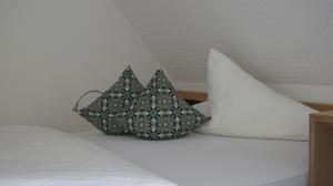 a bag sitting on a bed with two pillows at Hotel Anlage Heidelberg in Heidelberg