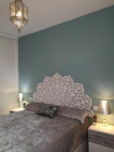 a bedroom with a large bed with a white headboard at Piso Sevilla in Gelves