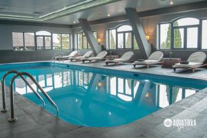 a pool in a hotel with chairs and a swimming pool at Q Resort and Spa in Săcele