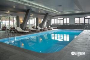 a pool in a hotel with chairs around it at Q Resort and Spa in Săcele