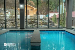- une piscine avec vue sur une maison dans l'établissement Q Resort and Spa, à Săcele