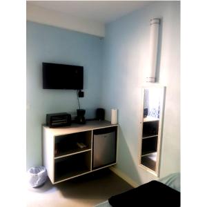 - un salon avec une télévision et un miroir dans l'établissement Careffe Suites Unit 4, à Cap Estate