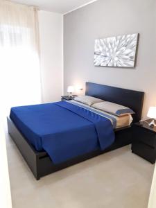 ein Schlafzimmer mit einem blauen Bett in einem Zimmer in der Unterkunft Suite Rent Milan 2 in Mailand