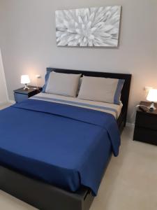 a blue bed in a room with two lamps at Suite Rent Milan 2 in Milan