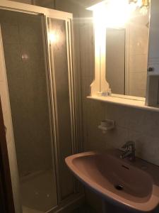 a bathroom with a shower and a sink and a mirror at Hotel Carillon in Lavena Ponte Tresa