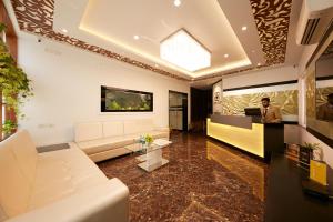 a man sitting at a desk in a living room at Al Noor Palace Business Class Hotel in Chennai