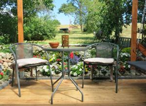 zwei Stühle und ein Tisch auf einer Terrasse in der Unterkunft Bülows kleines Ferienhaus in Thiessow + 2 Fotos