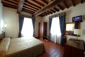 a bedroom with a bed and two large windows at Corte Degli Estensi in Formigine