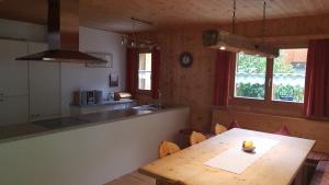 eine Küche und ein Esszimmer mit einem Holztisch in der Unterkunft Ferienhaus Valleu in Bartholomäberg