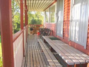 a porch with a wooden bench on a house at Holiday Home Viljamaan lomamökit 2 by Interhome in Vaskivesi