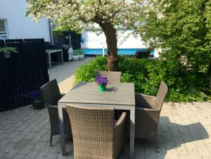 Kathrines Bed & Breakfast في سفينبورغ: طاولة مع كراسي وشجرة في الفناء