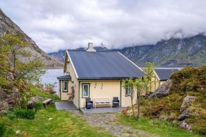 a house with a bench in front of a mountain at Sea-view house in Sund in Sund