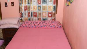 Dormitorio con cama rosa con sábana rosa en Cancun Guest House 1, en Cancún