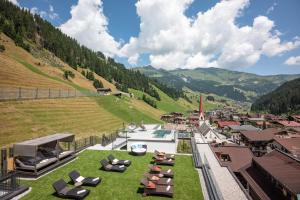 a resort with a pool and chairs on a hill at Ferienvilla Bergfried in Tux