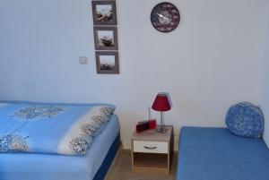 a bedroom with a bed and a chair and a clock at Bülows Ferienwohnung mit 2 Schlafzimmern in Klein Zicker