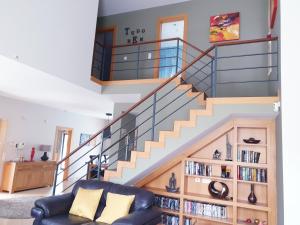 a living room with a staircase with a book shelf at Luxury Villa Corcovada Nicole with privat heated pool in Albufeira