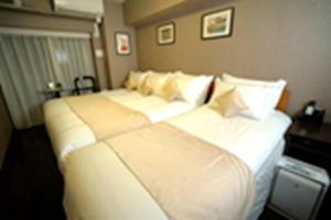 Postel nebo postele na pokoji v ubytování Le Tour Hotel Akihabara Ekimae 楽途ホテル秋葉原駅前店