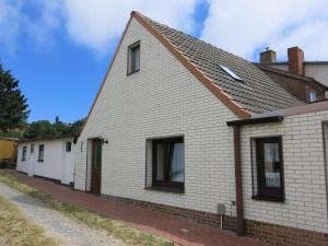 a white brick house with a pitched roof at Bülows Ferienwohnung mit 2 Schlafzimmern in Klein Zicker