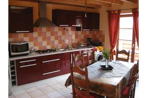 cocina con mesa y cocina con microondas en Gîte La Morandière, en Saint-Martin-en-Vercors