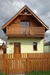 a small house with a deck on top of a fence at Víkendový domček Tis in Hrabušice