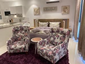 a bedroom with a couch and a chair and a bed at Purple Lily Studio Hawana Lagoons Salalah in Salalah