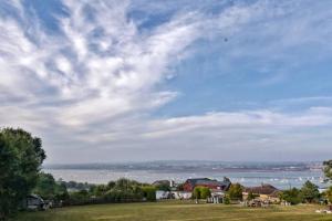 a field with a view of a body of water at Violet Mays Retreat in Starcross