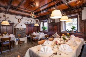 un restaurante con mesas y sillas blancas y techos de madera en Postgasthof Fischerwirt, en Walchsee
