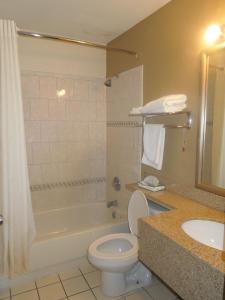 a bathroom with a toilet and a tub and a sink at Super 8 by Wyndham Waldorf in Waldorf