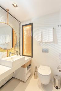 a bathroom with a sink and a toilet and a mirror at ROX Hotel Ankara in Ankara