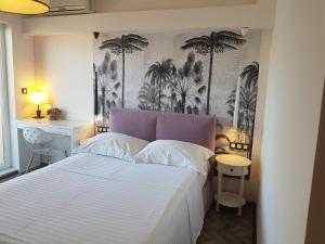 ein Schlafzimmer mit einem weißen Bett mit Palmen an der Wand in der Unterkunft Boutique Villa Revelin in Pag