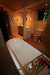 uma grande banheira branca numa casa de banho com WC em The Wookey Hole Inn em Wells