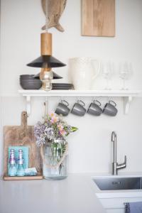 a kitchen shelf with a vase of flowers and a sink at Hapsal Dietrich apartemendid in Haapsalu