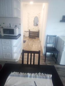 a kitchen with a table and two chairs and a microwave at Rozinka apartman in Dunaújváros