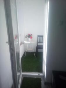 Habitación pequeña con mesa y alfombra verde. en Rozinka apartman, en Dunaújváros