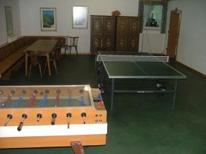 a ping pong table in a living room with a table at Hotel Gasthof Buchbauer in Bad Sankt Leonhard im Lavanttal