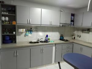 a kitchen with white cabinets and a blue table at Duplex a pasitos del centro contactar número primer foto in Posadas +6 photos