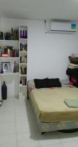 a bedroom with a bed and a book shelf at Duplex a pasitos del centro contactar número primer foto in Posadas