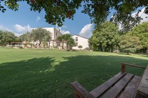 a park with a wooden bench in the grass at Relais Torre Marabino in Ispica