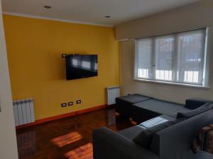 sala de estar con sofá y TV de pantalla plana en Habitacion privada Chauvin Kelapa en Mar del Plata