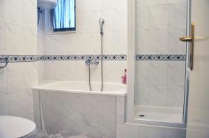 y baño con ducha, bañera y aseo. en Apartment Center en Split