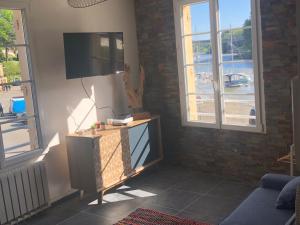 a living room with a flat screen tv on a wall at studio vue sur le Port saint Goustan classé 3 étoiles! in Auray