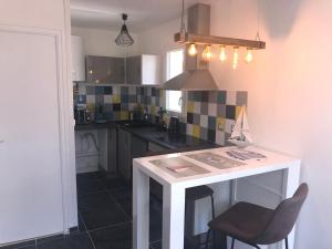 a kitchen with a white island in a room at studio vue sur le Port saint Goustan classé 3 étoiles! in Auray