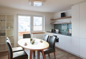 a kitchen with a table and chairs in a kitchen at Haus Harmony Apartments in Ramsau am Dachstein