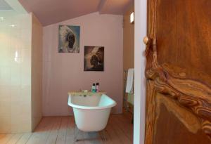 a bathroom with a white tub and a sink at The Wookey Hole Inn in Wells