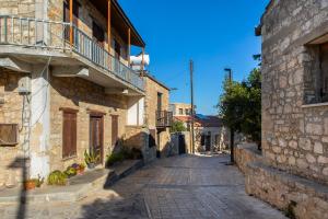 une ruelle dans une vieille ville avec un balcon dans l'établissement Akamantida Platea, à Pano Arodes